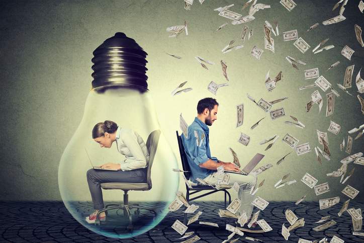 woman-sitting-inside-electric-lamp-using-working-on-computer-in-corporate-office-next-to-young-entrepreneur-man-under-money-rain